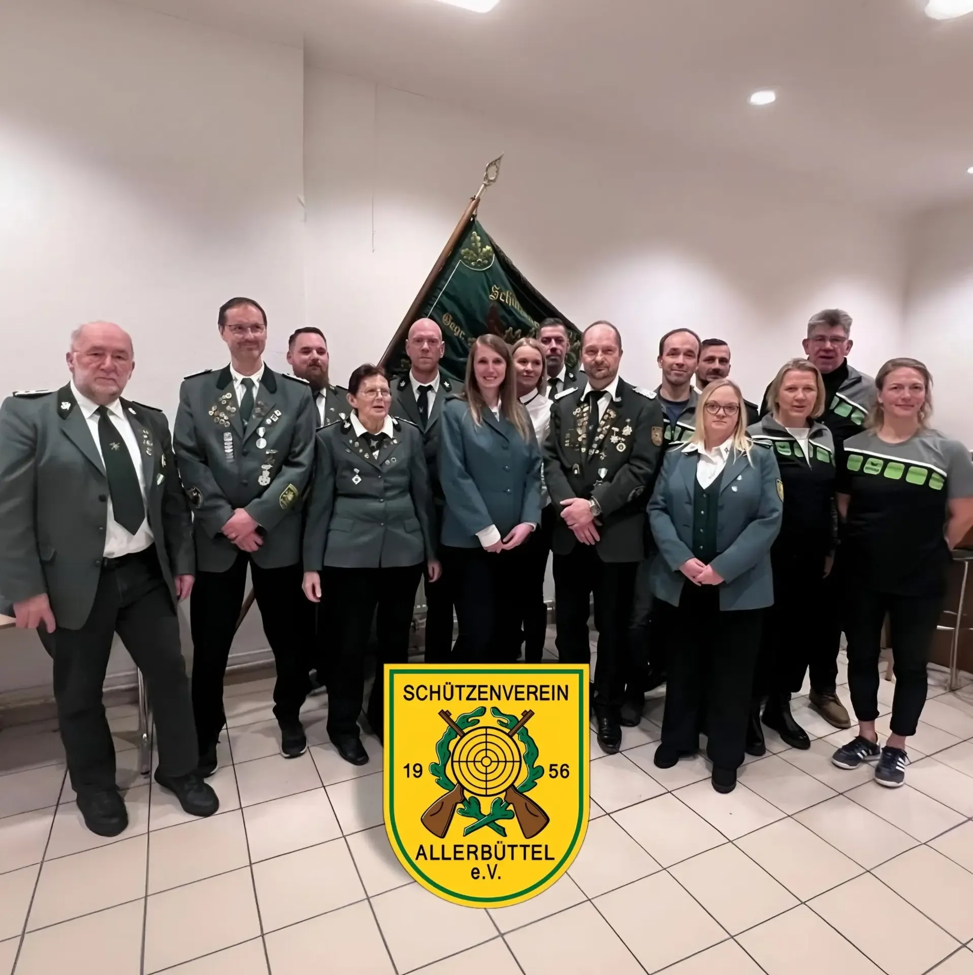 Gruppenfoto der Vereinsmitglieder, viele in Schützenuniform, mit Vereinsfahne