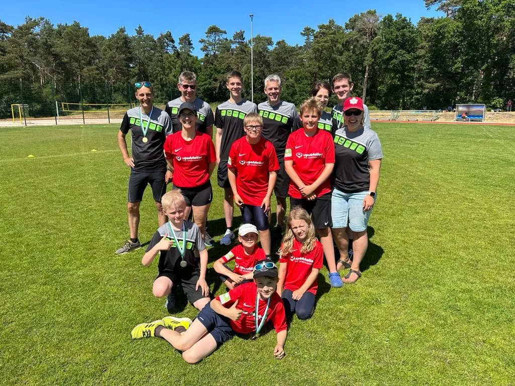 Gruppe mit Medaillen auf einem Sportplatz