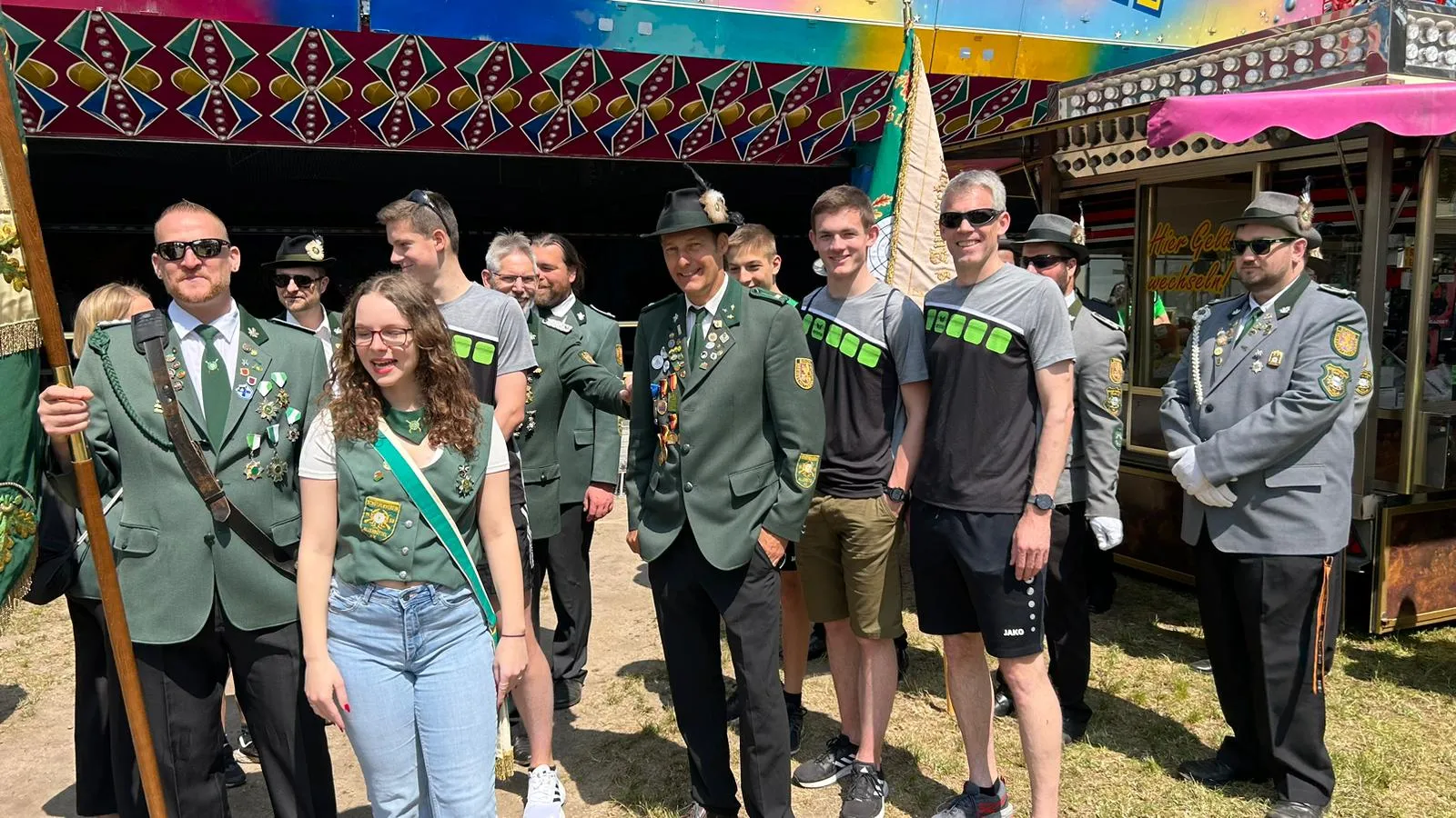 Mitglieder des Schützenvereins in festlicher Kleidung vor einem Festplatz
